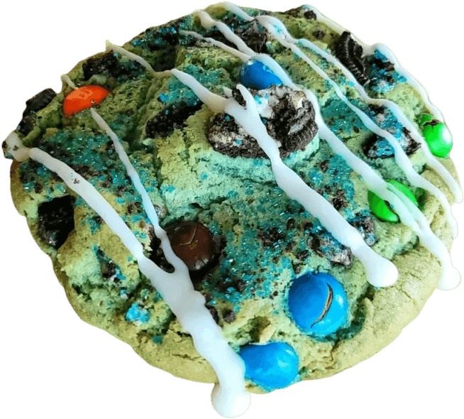 Colorful cookie with blue and orange candies and white drizzle.